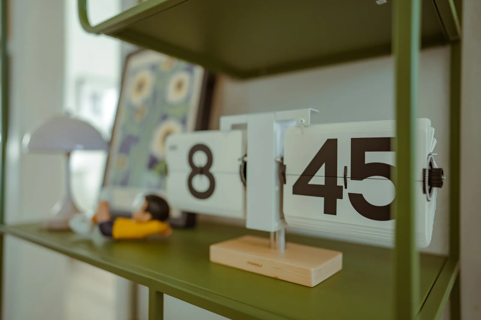 Retro flip clock showing 8:45 on a shelf in a mid-century style room