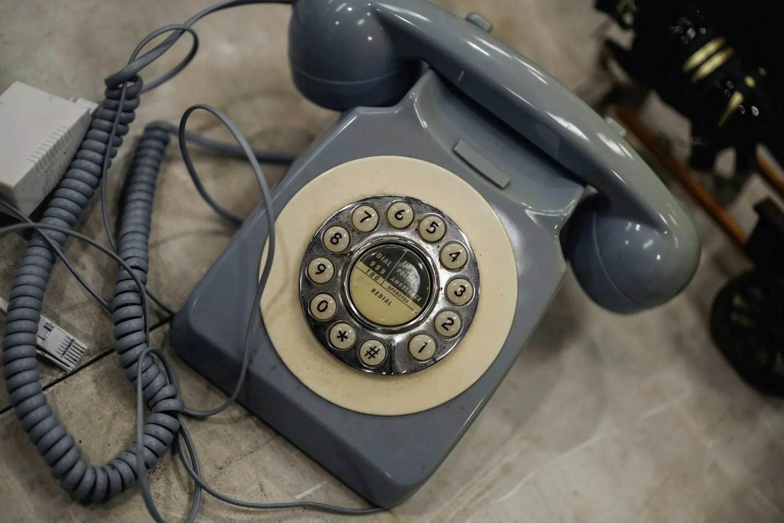 Vintage blue rotary dial telephone on a wooden table, the look most retro landline phones copy